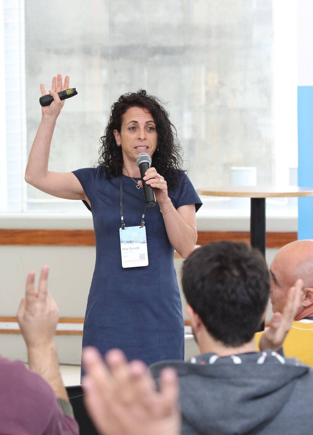 Iffat Bar-Kol Grecht speaking to an audience, hand raised